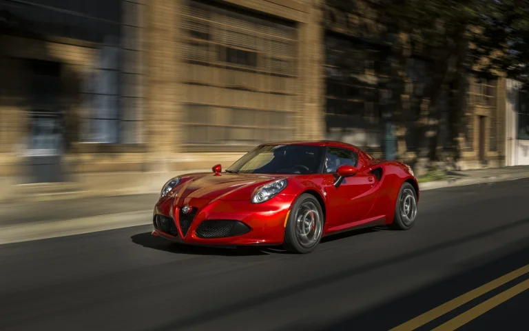a red alfa romeo 4c speeding down a city street, alfa romeo 4c, alfa romeo, cars, automobiles, houses, buildings, movement, roads, highways, motorways, avenues, driveways, passageways, speed, sports cars, streets, auto, vehicles