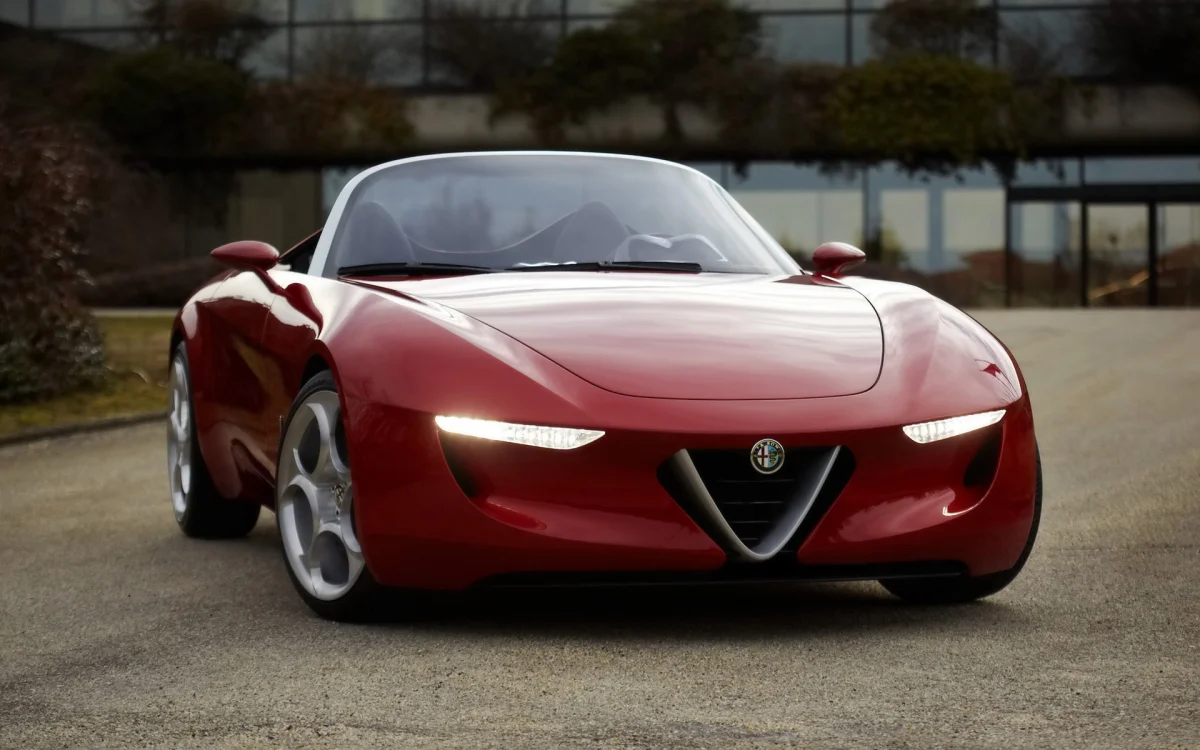 Червона Alfa Romeo 2uettottanta на асфальтовому майданчику