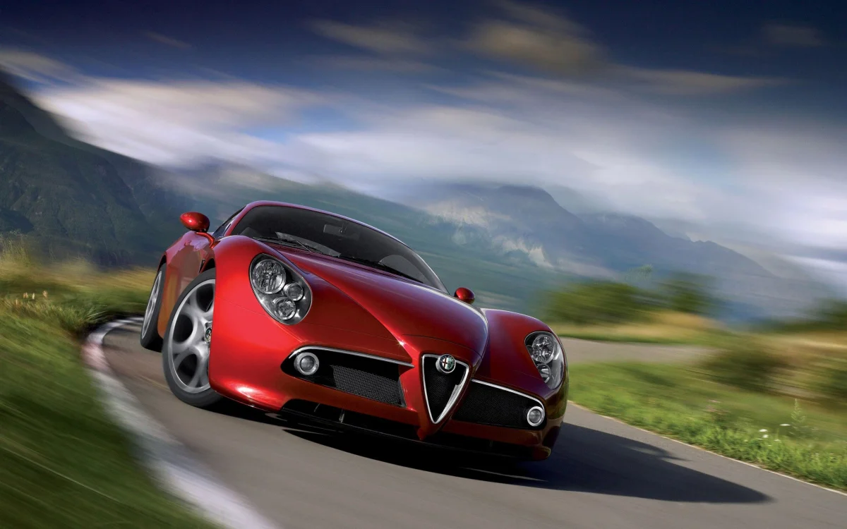 Червона Alfa Romeo 8C Competizione на звивистій гірській дорозі