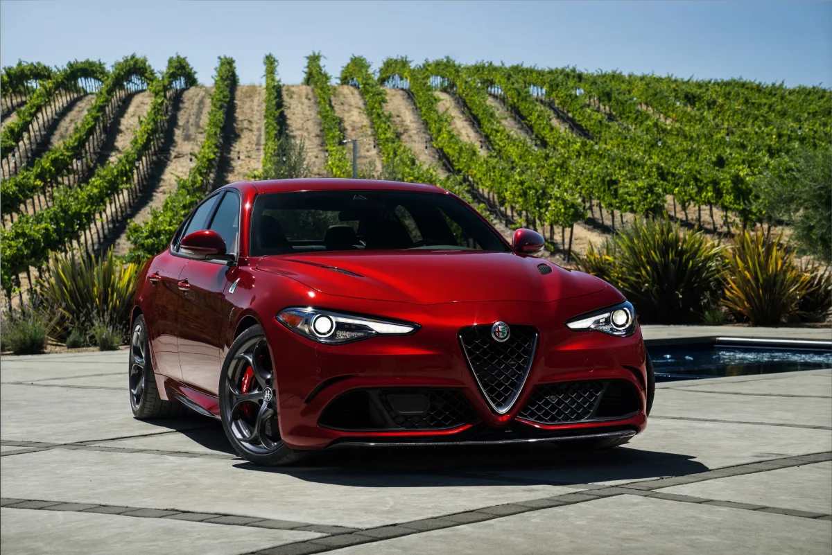 Красная Alfa Romeo Giulia на фоне залитых солнцем итальянских виноградников