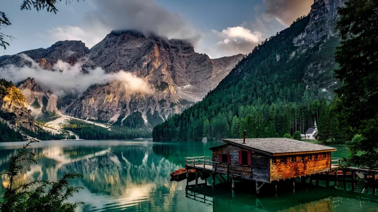 a wooden cabin on the shore of lake braies, alps, boats, motorboats, speedboats, churches, clouds, forest, forests, italy, lakes, bodies of water, landscapes, little houses, huts, cottages, mountains, peaks, hills, reflections, snow, trees, nature, world