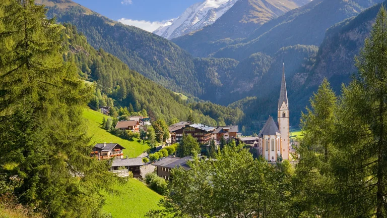 the austrian village of heiligenblut, surrounded by snow-capped peaks, the alps, austria, alps, cathedrals, churches, fir trees, coniferous trees, forest, forests, landscapes, little houses, huts, cottages, mountains, peaks, hills, snow, villages, settlements, nature, world