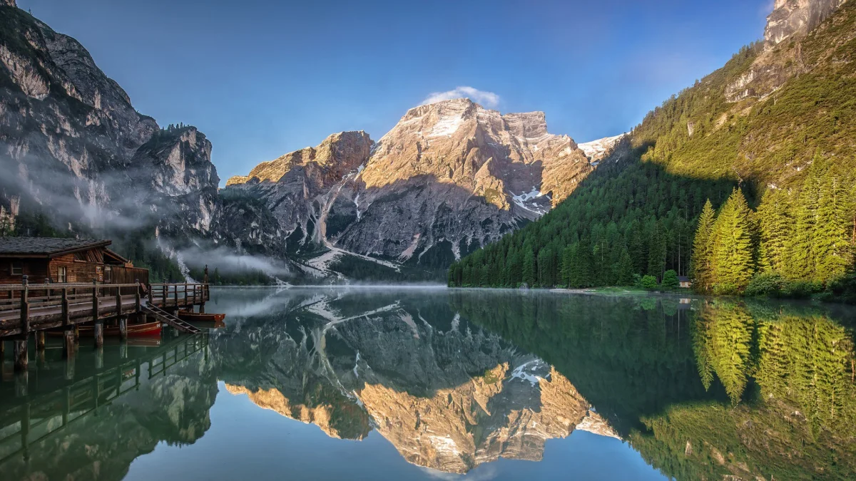 morning sunbeams on lake braies, alps, boats, motorboats, speedboats, cliffs, docks, piers, fog, forest, forests, italy, lakes, bodies of water, landscapes, little houses, huts, cottages, morning, mountains, peaks, hills, reflections, sunrises, dawn, nature, world