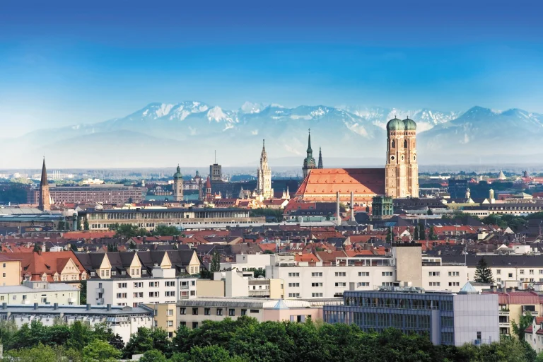 a panoramic view of munich with the frauenkirche against the backdrop of the alps, munich, alps, cathedrals, churches, cities, city, cityscape, cityscapes, germany, mountains, peaks, hills, roofs, sky, architecture, world