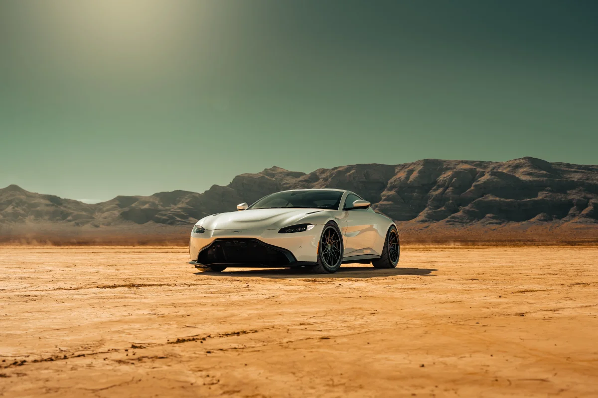 A white Aston Martin Vantage against a desert backdrop