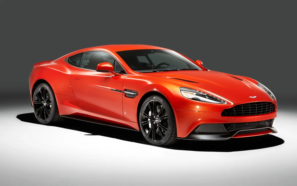 A bright orange Aston Martin Vanquish under studio lighting