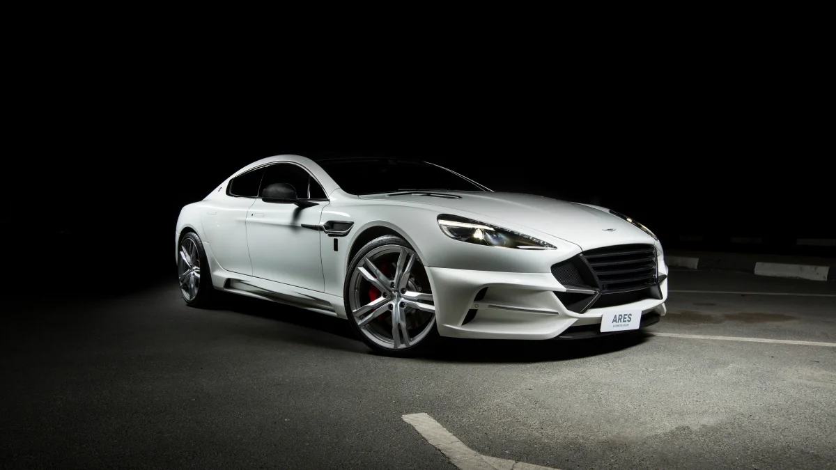 A snow-white Aston Martin Rapide in the glow of the night spotlights