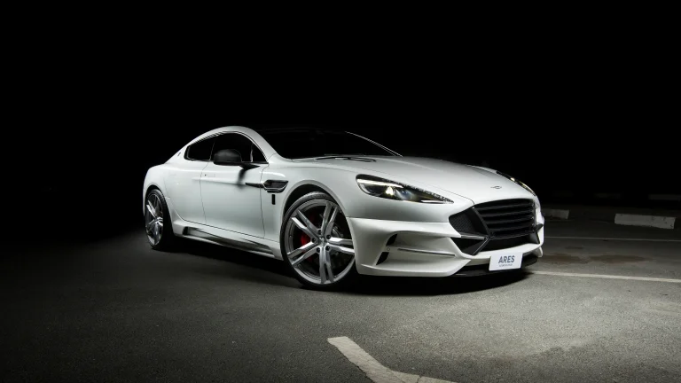 білосніжний aston martin rapide у світлі нічних прожекторів, aston martin rapide, aston martin, астон мартін, диски, колеса, дороги, шляхи, траси, шосе, магістралі, автостради, проспекти, проїзди, машини, автомобілі, спорткари, фари, авто