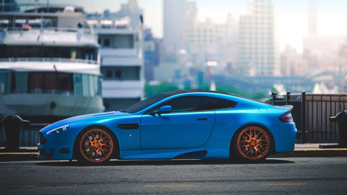 A bright blue Aston Martin V8 Vantage on the New York waterfront