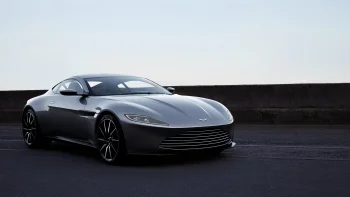 A silver Aston Martin DB10 on an empty road in the early morning hours
