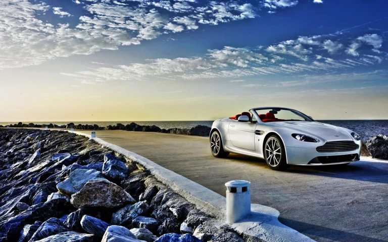 білосніжний кабріолет aston martin v8 vantage на прибережній дорозі, aston martin v8, aston martin, астон мартін, диски, колеса, дороги, шляхи, траси, шосе, магістралі, автостради, проспекти, проїзди, захід сонця, кабріолети, машини, автомобілі, море, моря, небо, спорткари, фари, хмари, авто