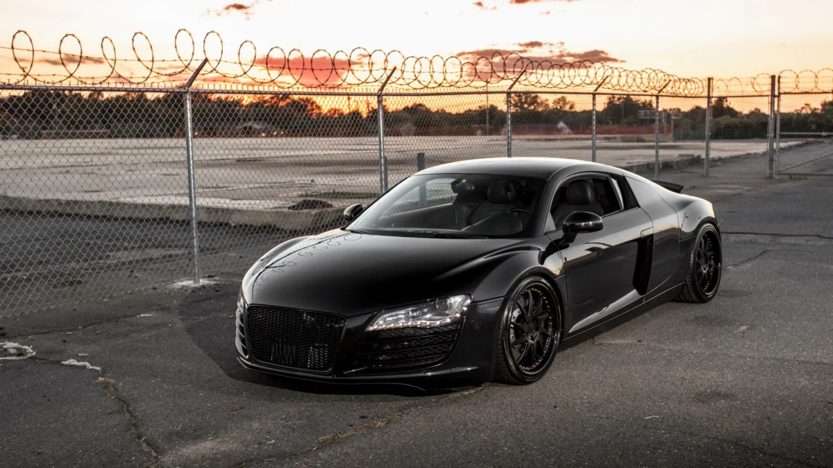 Черная Audi R8 на закате у ограждения