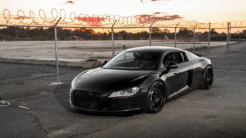 Черная Audi R8 на закате у ограждения