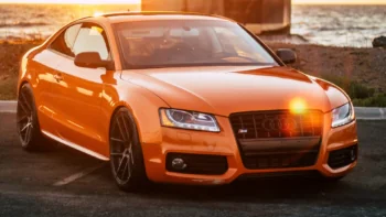 Оранжевое купе Audi S5 на фоне морского побережья