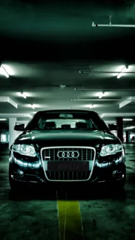 Черный седан Audi в свете ламп подземного паркинга