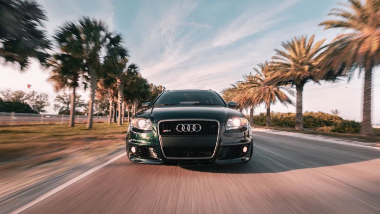 Темно-зеленый Audi RS4 на дороге среди пальм