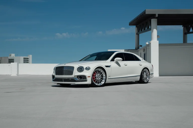 a snow-white bentley flying spur on the roof of a parking garage, bentley flying spur, bentley, cars, automobiles, discs, wheels, roofs, sedans, sky, auto, vehicles