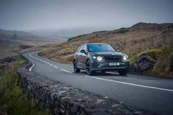 Bentley Bentayga на извилистой дороге среди холмов