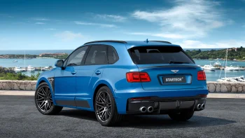 A blue Startech Bentley Bentayga against the backdrop of the seashore