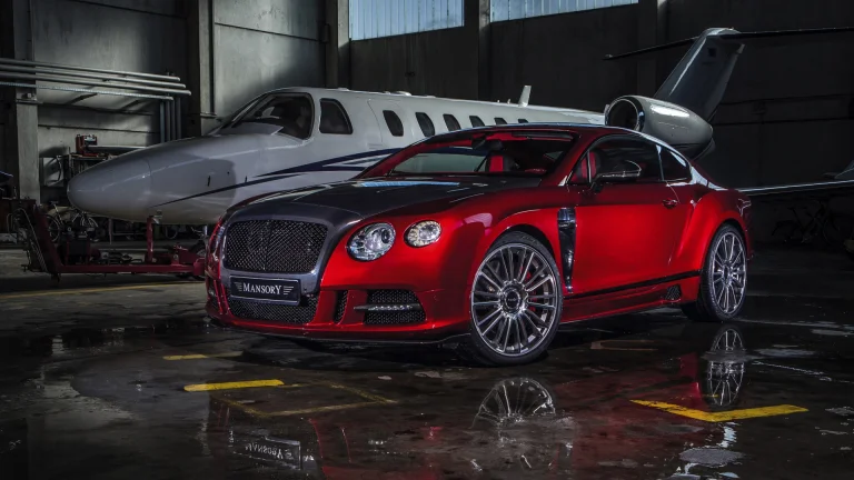 a red bentley continental gt mansory in a hangar next to an airplane, bentley continental gt, airplanes, aircraft, aviation, bentley, cars, automobiles, compartment, discs, wheels, reflections, sports cars, auto, vehicles