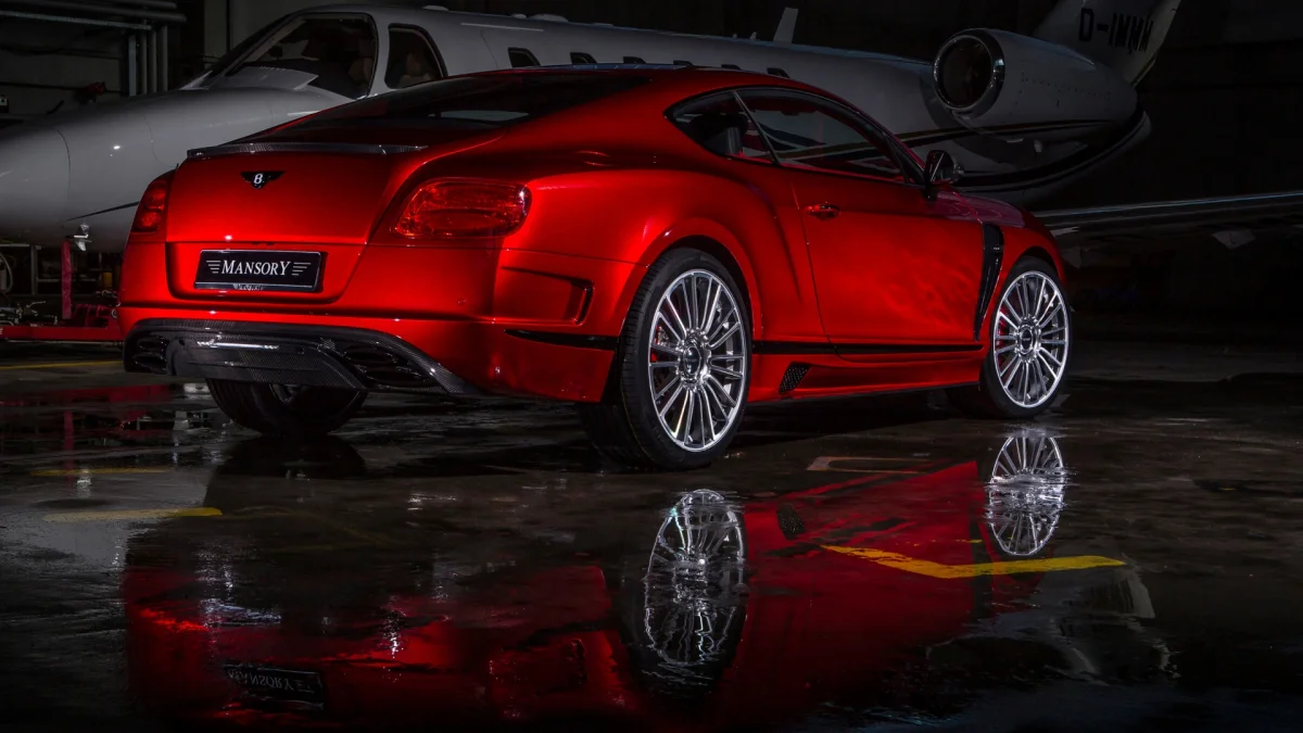 Червоний Bentley Continental GT від Mansory в ангарі на тлі приватного літака