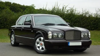 A black Bentley Arnage against a backdrop of English greenery