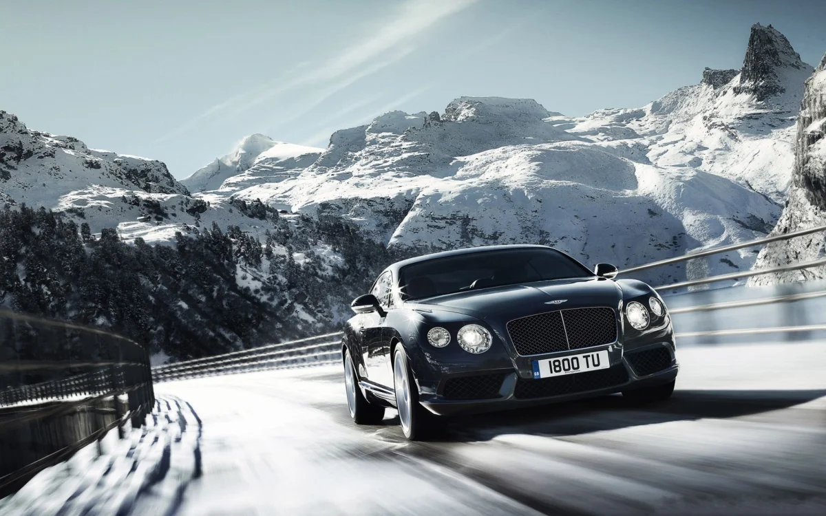 A Bentley Continental GT on a snow-covered mountain road in the Alps