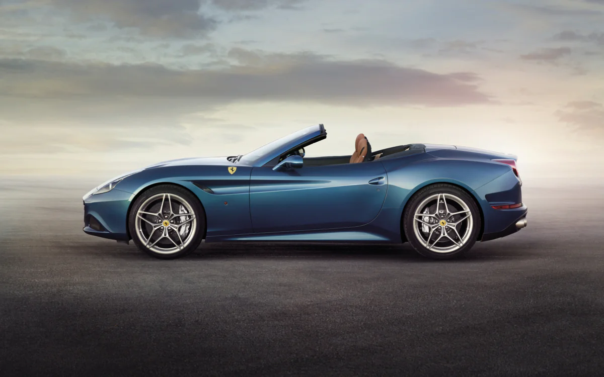 Синій Ferrari California T на тлі неба перед заходом сонця
