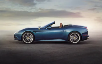 Синий Ferrari California T на фоне предзакатного неба