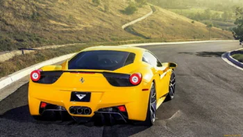 A yellow Ferrari 458 Italia on a winding mountain road