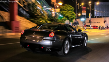A gray Ferrari 599 GTB Fiorano speeding through the city at night