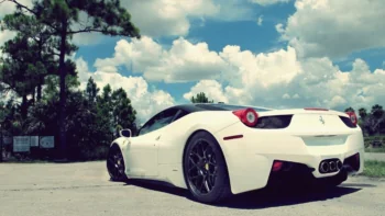A white Ferrari 458 Italia against the backdrop of a summer sky