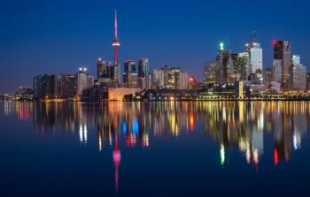 Огни ночного Торонто и отражение башни CN Tower в водах озера Онтарио