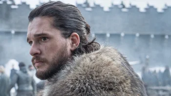 Jon Snow in a fur cloak against the backdrop of Winterfell's icy walls