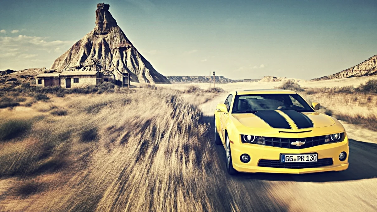 Желтый Chevrolet Camaro на фоне пустынных скал