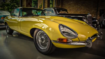 Желтый Jaguar E-Type в интерьере старого гаража
