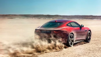 Красный Jaguar F-Type поднимает облако пыли на солончаке