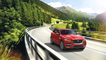 A red Jaguar F-Pace on a winding mountain road