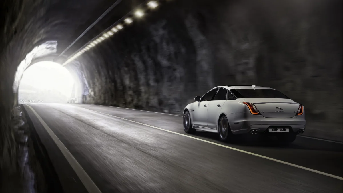 Білий Jaguar XJ, що виїжджає з темного гірського тунелю