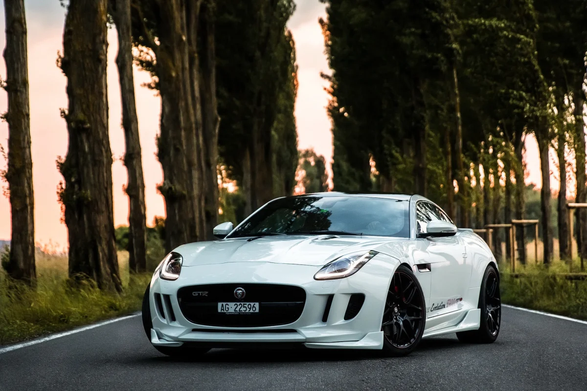 Білий Jaguar F-Type на порожній дорозі