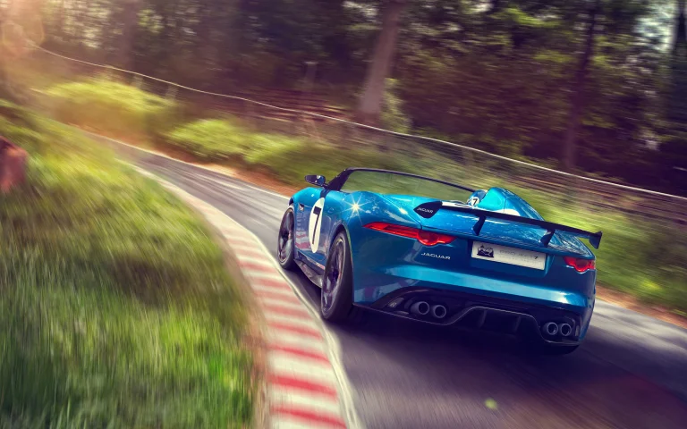 A blue Jaguar F-Type Project 7 on a winding forest road