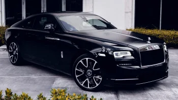 Черный Rolls-Royce Wraith на парковке у здания