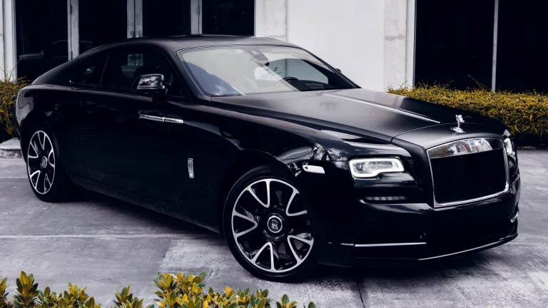 Черный Rolls-Royce Wraith на парковке у здания