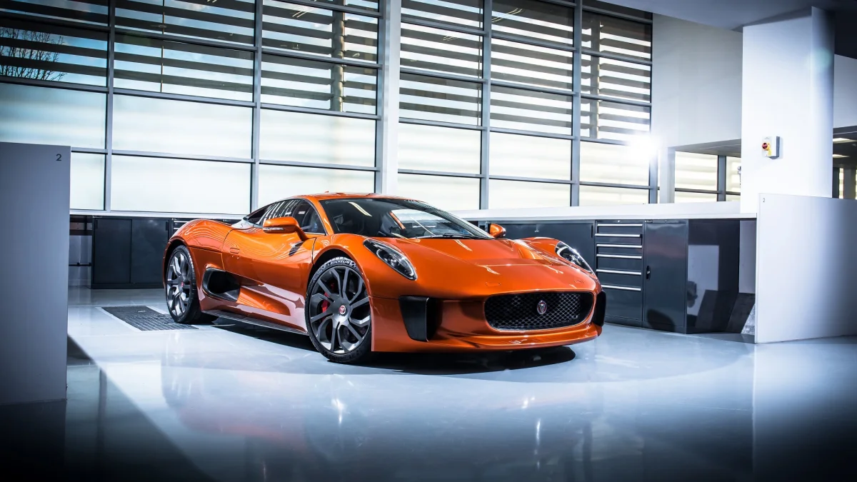 An orange Jaguar C-X75 in the brightly lit interior of the workshop