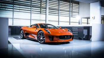 Оранжевый Jaguar C-X75 в светлом интерьере мастерской