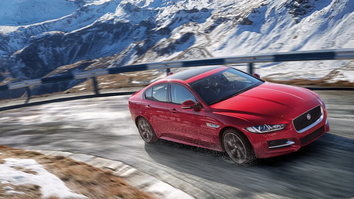 A red Jaguar XE on a snow-covered mountain road