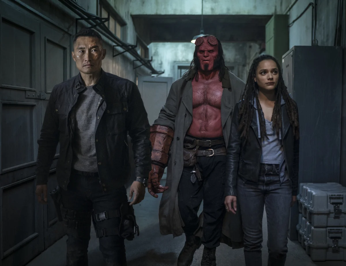 Hellboy, Ben Daimio, and Alice Monaghan in a gloomy hallway