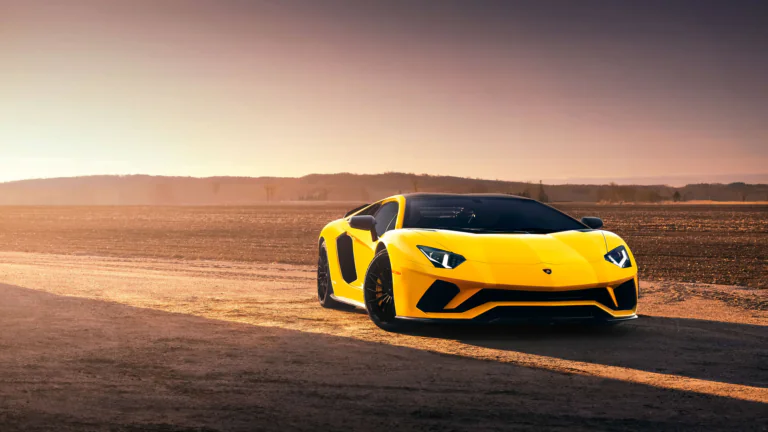 Желтый Lamborghini Aventador на фоне закатного поля