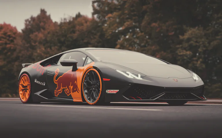 Черный Lamborghini Huracan с символикой Red Bull на фоне осеннего леса