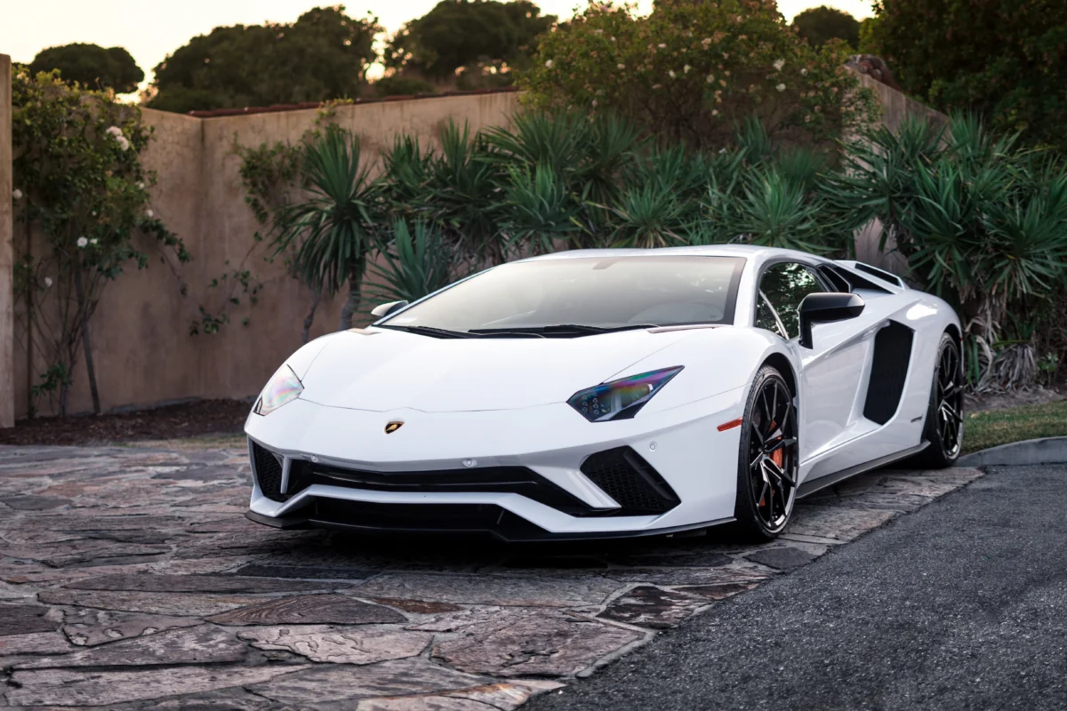 Белый Lamborghini Aventador S на фоне вечернего сада